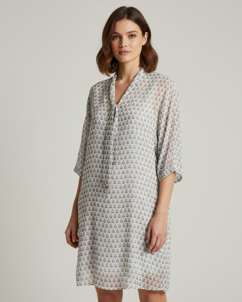 Woman wearing a patterned dress on a plain background